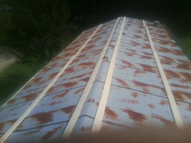 Rusted metal roof panels with new wood purlins before replacement — Storm Damage Roof Repair in Antioch by Roofing Brothers
